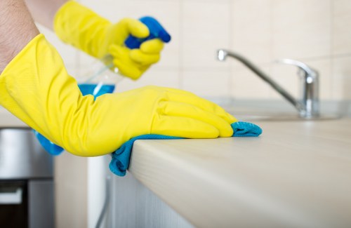 A staff member wearing PPE while cleaning carpets